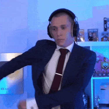 a man wearing headphones and a suit is dancing