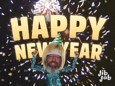 a man in a party hat stands in front of a fireworks display that says happy new year