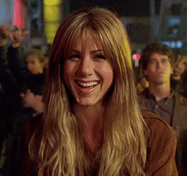 a woman with long blonde hair and bangs smiles for the camera