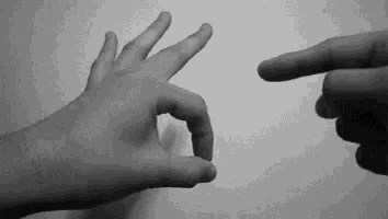 a black and white photo of a person 's hands making an ok sign