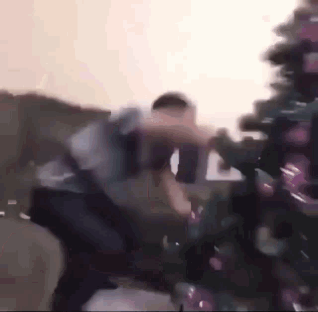 a man is standing next to a christmas tree in a room .