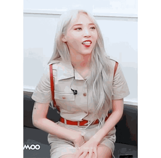 a woman with white hair is sitting on a couch and the word moo is on the bottom