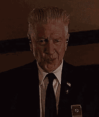 a man in a suit and tie has a badge on his chest that says ' us army '