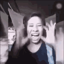 a woman is making a funny face and making a peace sign with her hand .