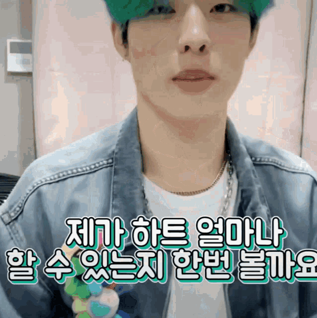 a young man with green hair is wearing a denim jacket