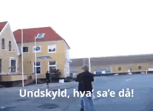 a man standing in front of a building that says hotel on it