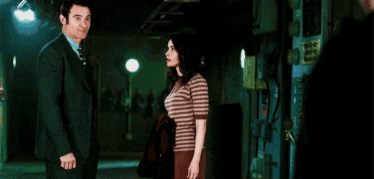 a man and a woman are standing next to each other in a hallway .