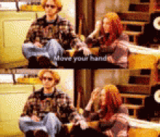 a man and a woman are sitting on a couch with a sign that says move your hands ..
