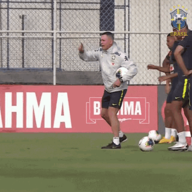 a man holding a soccer ball in front of a sign that says " brahma "