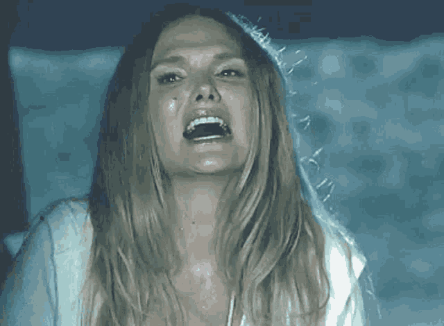 a woman is screaming with her mouth open and her tongue sticking out