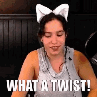 a woman wearing a cat ear headband says what a twist .