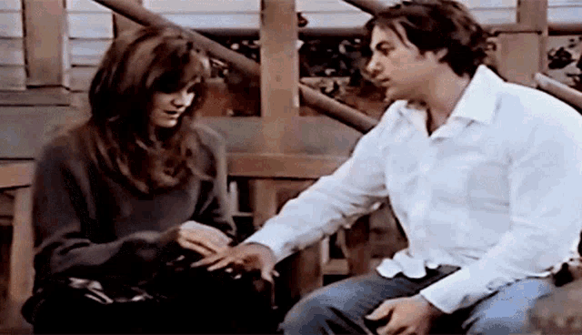 a man and a woman are sitting next to each other on a porch