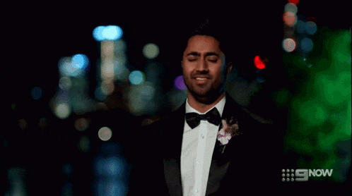 a man is smiling with his eyes closed and his mouth open .