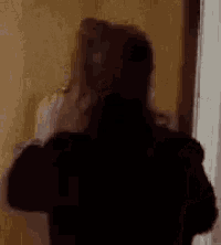 a silhouette of a woman standing in front of a door in a dark room .