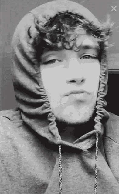 a black and white photo of a man wearing a hoodie