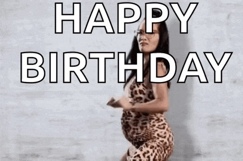 a pregnant woman in a leopard print dress is dancing with the words `` happy birthday '' .