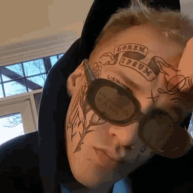 a man with a tattoo on his face and sunglasses that say lorem ipsum