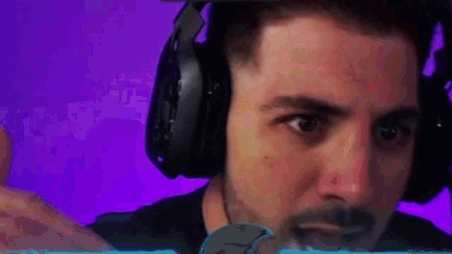 a man wearing headphones is looking at the camera with a purple background