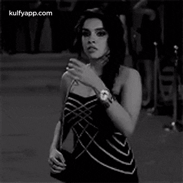 a black and white photo of a woman touching her hair .