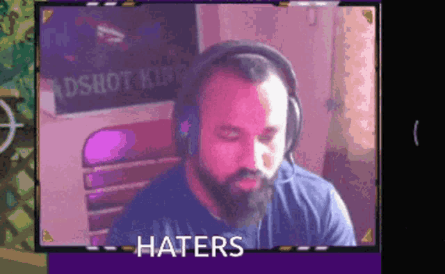 a man with a beard wearing headphones has the word haters on the bottom