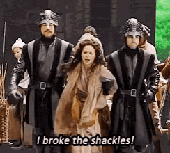 a group of people in medieval costumes are standing next to each other .