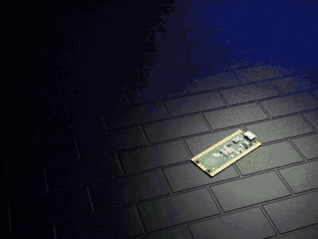 a small electronic device is laying on a black tiled floor