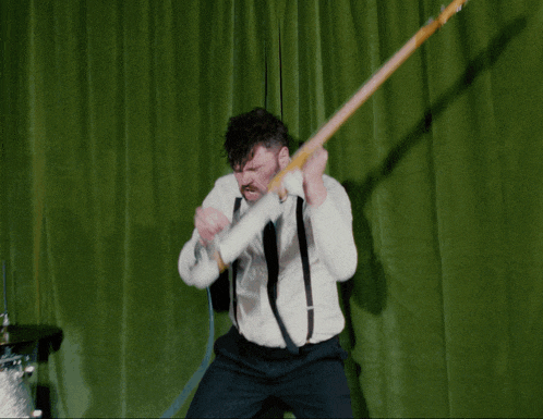 a man in a white shirt and black tie is playing a guitar