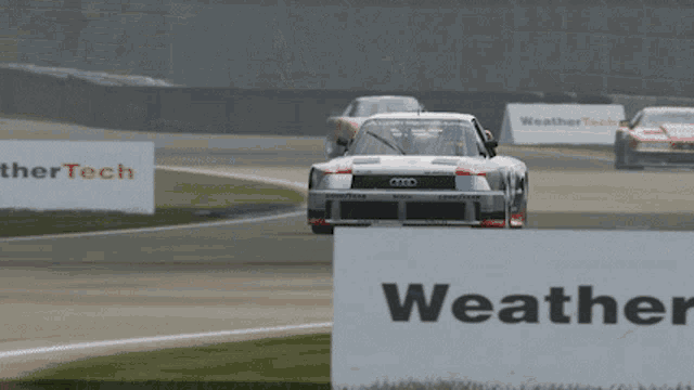 a race car is on a track with a sign that says weather tech