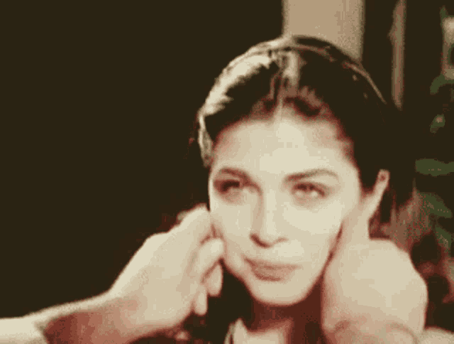 a close up of a woman 's face with a man 's hand on it