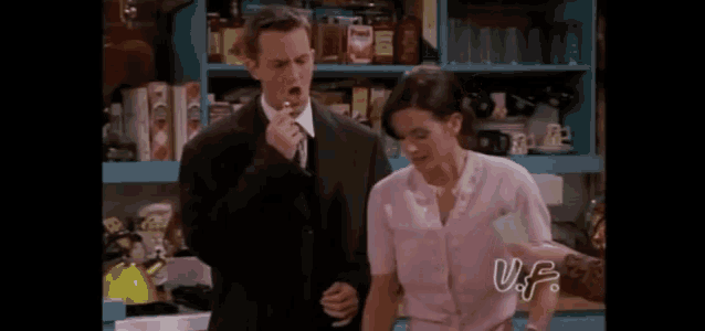 a man and a woman are standing in a kitchen .