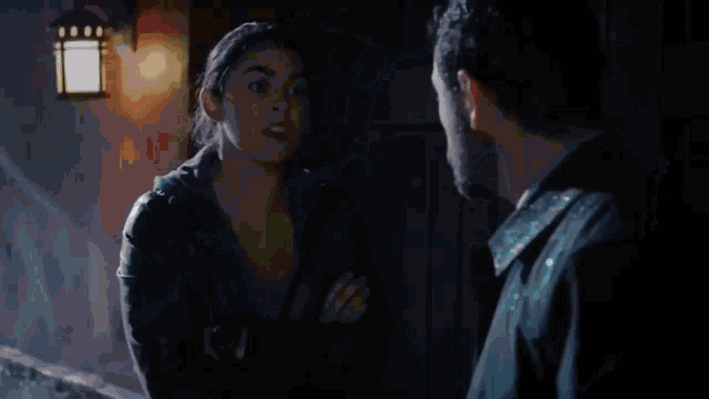 a woman in a ponytail is looking down at a man in a room .