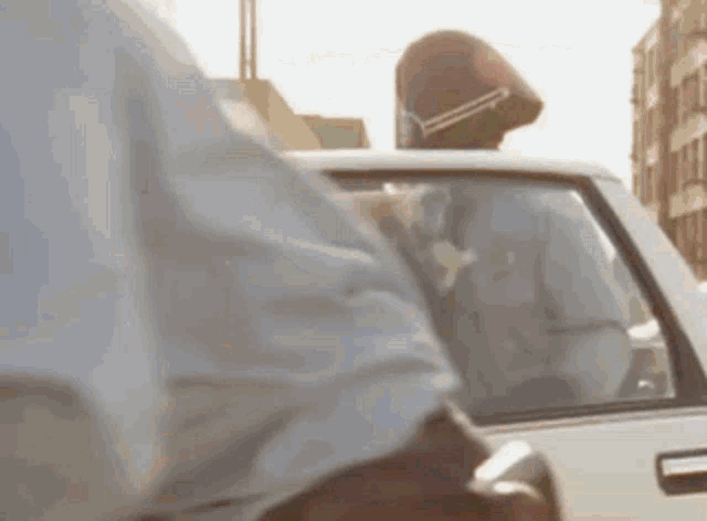 a man in a helmet is sitting in the back seat of a white car .