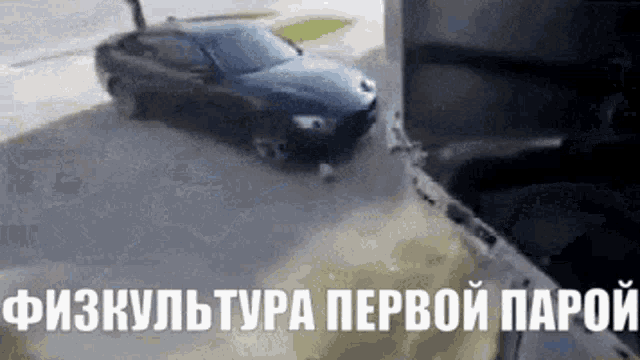 a black car is parked on the side of the road in a parking lot in a foreign language .