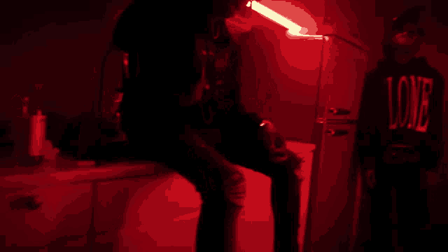 a man giving the middle finger in a dark room with red lights