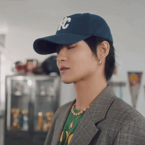 a man wearing a kc hat and a plaid jacket