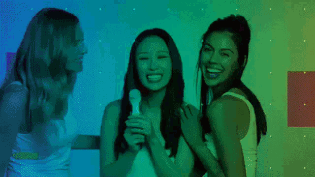 three women are standing next to each other with a microphone in their hands