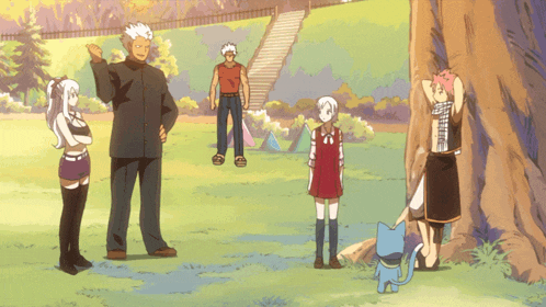 a group of people standing in a park with a cat