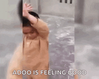 a man is standing in a pool of water with the words `` adoo is feeling good '' written on the screen .