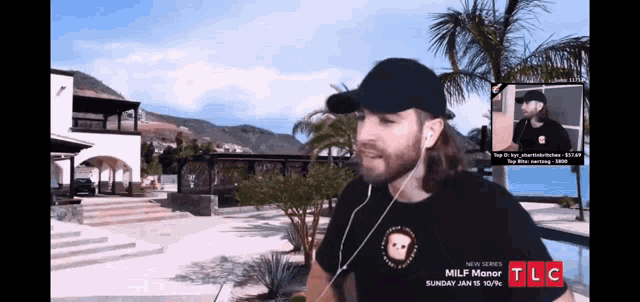 a man wearing a black hat and a t-shirt that says ' milf manor '