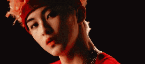 a close up of a person wearing a red headband and a necklace .