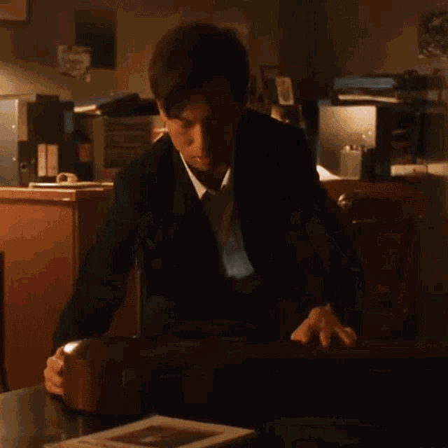 a man in a suit is sitting at a table with a briefcase on it