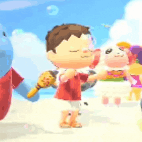 a boy in a red shirt is standing on a beach holding a toy .