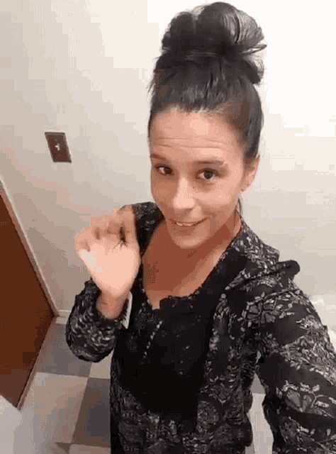 a woman taking a selfie with a light switch on the wall