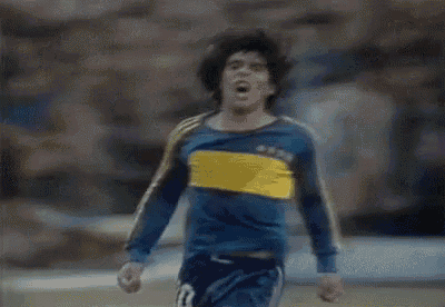 a blurry picture of a man in a blue and yellow jersey standing on a field .