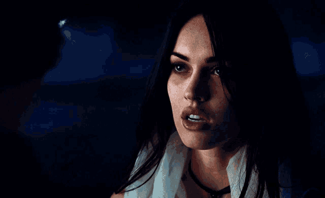 a close up of a woman in a dark room