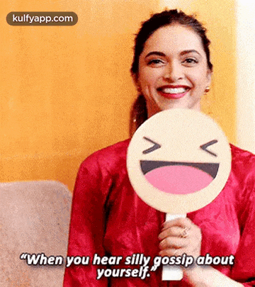 a woman is holding a smiley face in front of her face and says `` when you hear silly gossip about yourself . ''