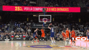 a basketball game is being played in front of a sign that says ' per la compra '