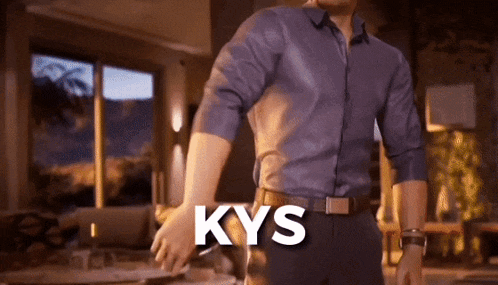a man in a blue shirt and black pants is standing in a living room with the word kys written on the bottom of his shirt