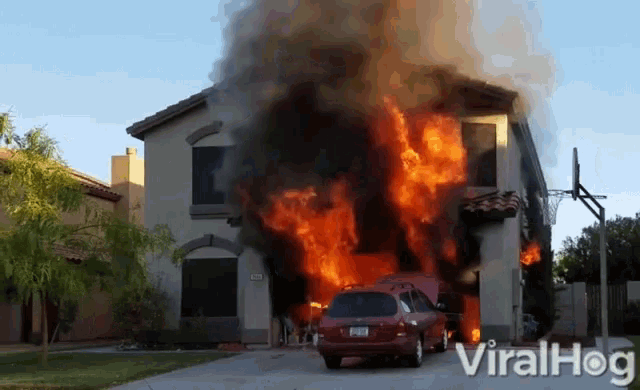 a car is parked in front of a house that is on fire and says viralhog on the bottom right