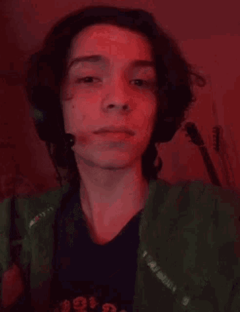 a young man with braces on his teeth is making a funny face while wearing headphones .